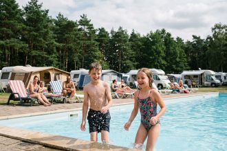 Deux enfants jouent dans une piscine de camping en plein air
