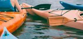 person riding on orange kayak during daytime