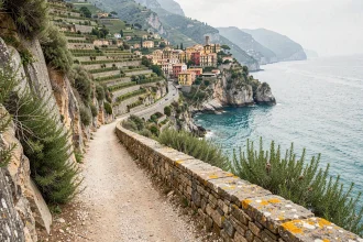 Sentier côtier des Cinq Terres longeant les falaises avec vue sur le village de Vernazza et la mer Ligure