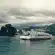 white and red passenger boat floating on body of water near island